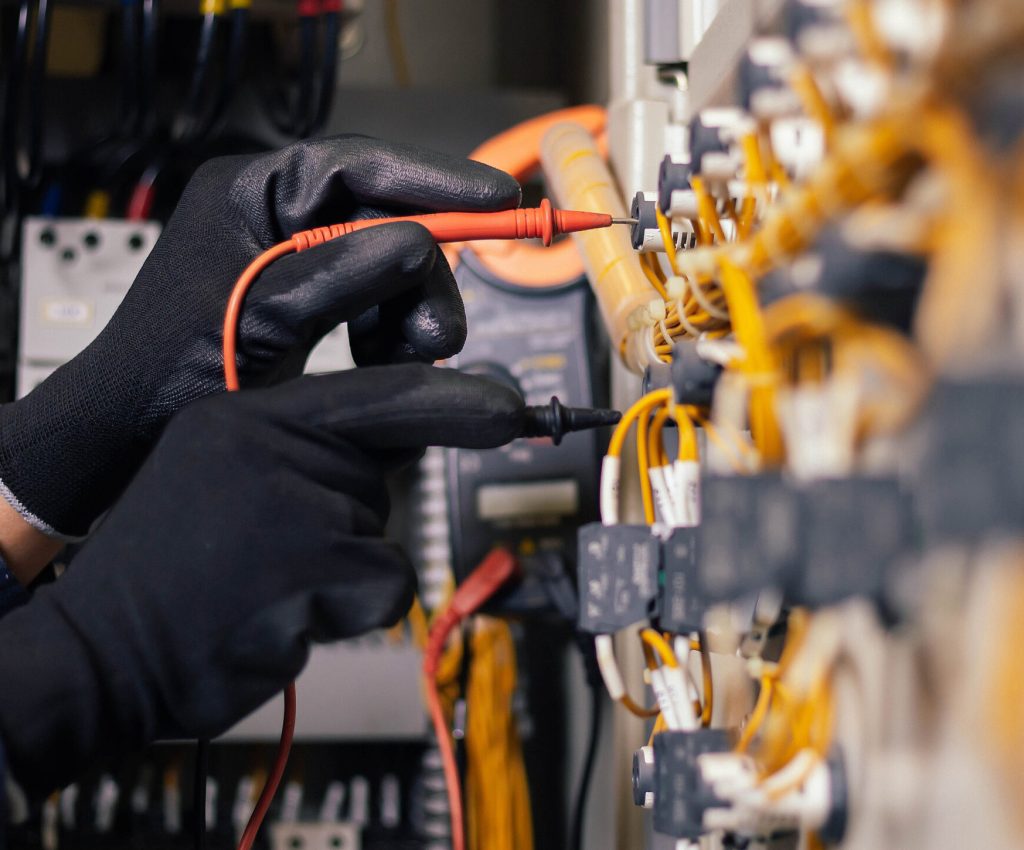 Electrician engineer work tester measuring voltage and current of power electric line in electical cabinet control.and wires on relay protection system. Bay control unit. Medium voltage switchgear.